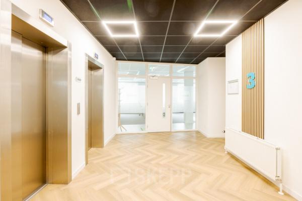 De lichte hal in het kantoorpand aan de Zuiderzeelaan 15-25 in Zwolle toont een modern interieur met lift en doorgang naar kantoorruimtes. Geschikt voor bedrijven die kantoorruimte willen huren.