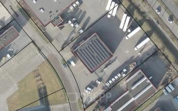 Een luchtfoto van het kantoorpand aan de Pascalweg 6 in Zwolle, met diverse voertuigen en omliggende infrastructuur zichtbaar.